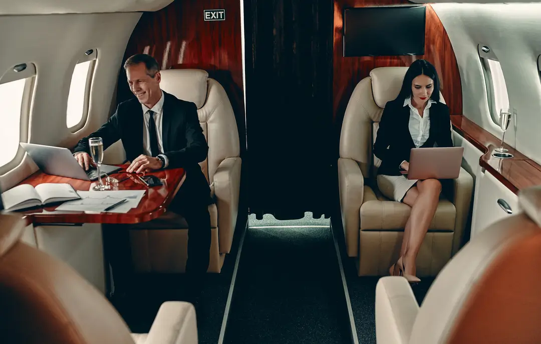 noleggio jet privato flyness viaggi business lusso Professionisti lavorano a bordo di un jet privato, simbolo dei vantaggi dei voli con jet privato Flyness per business travel e viaggi lusso.