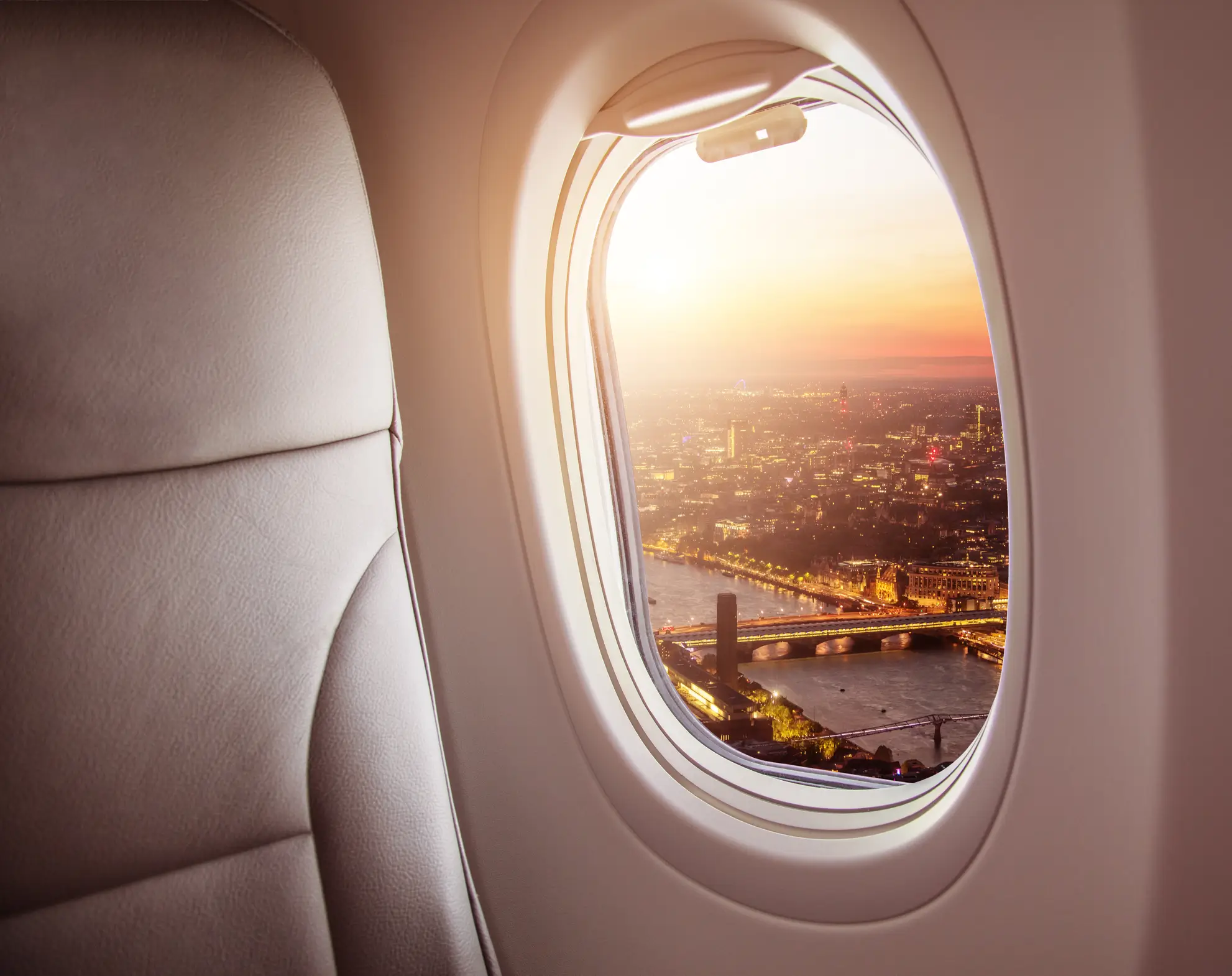Vista notturna su città europea da finestrino aereo privato. Flyness noleggio jet privati business travel e VIP.