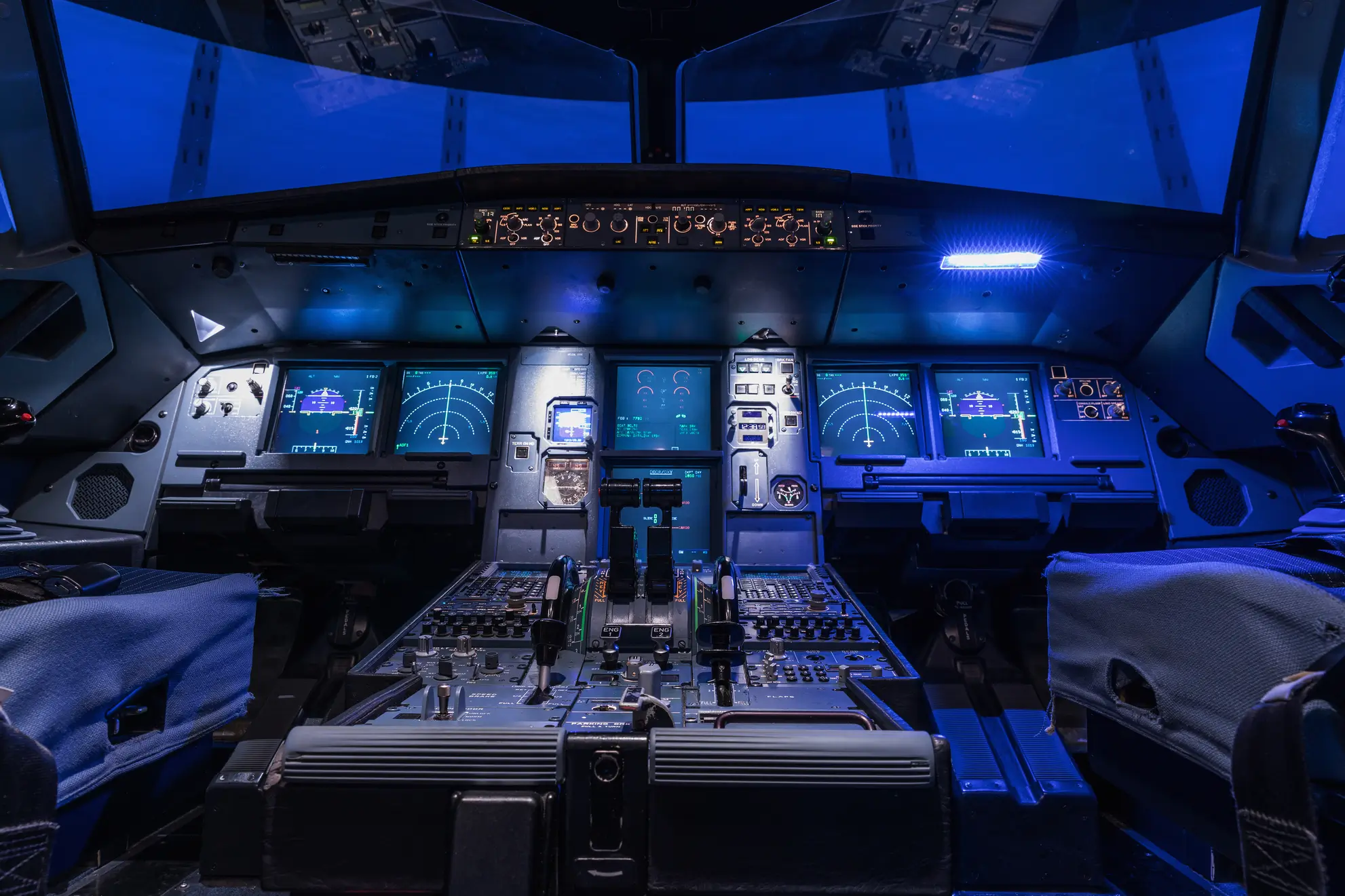 cockpit-aereo-digitale-innovazione-volo-flyness Cockpit digitale illuminato di un aereo moderno, simbolo dell’innovazione tecnologica nei viaggi aerei. Flyness, noleggio aerei charter.
