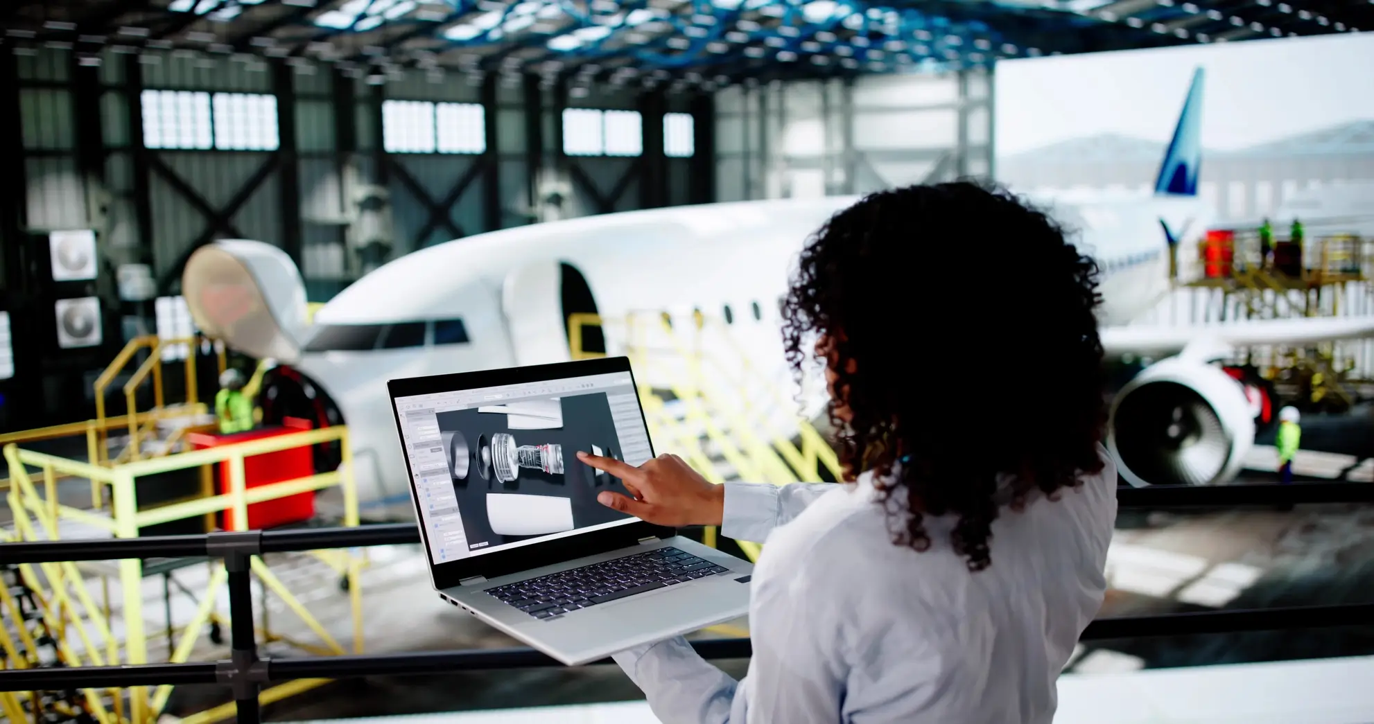 tecnologia- digitale-sicurezza-voli-aerei-flyness Ingegnere aeronautico analizza componenti digitali su laptop durante la manutenzione di un aereo. Flyness, noleggio aereo e jet privati.