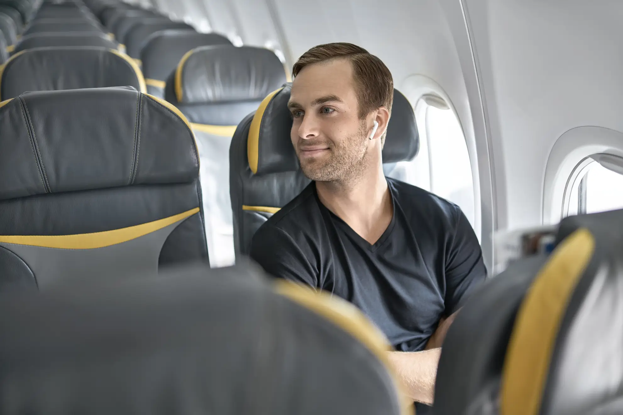 Passeggero seduto in cabina con comfort e ampio spazio personale. Esempio di volo charter Flyness per atleti in trasferta.