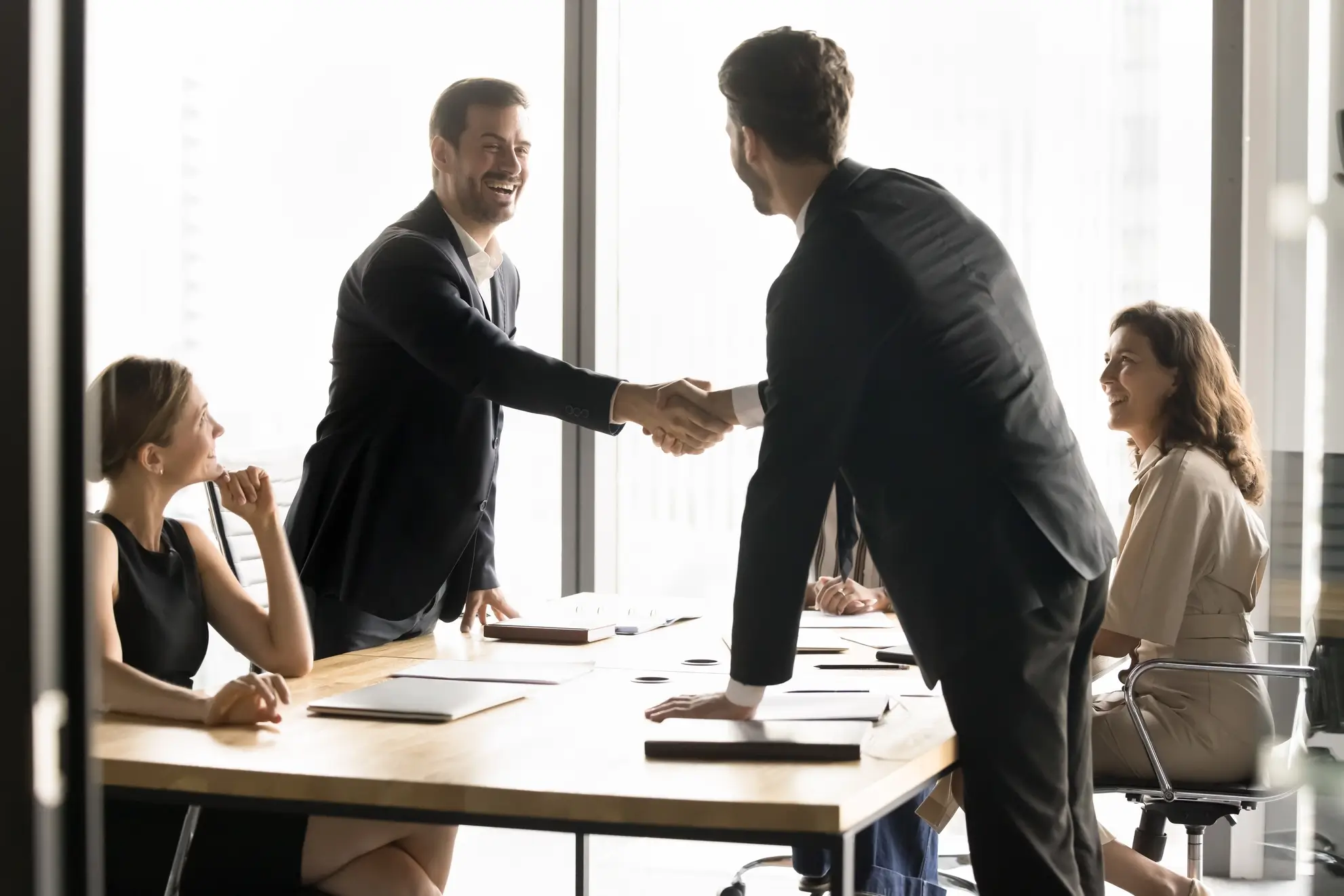 Due professionisti si stringono la mano durante un incontro aziendale: Flyness, il partner strategico per il noleggio aereo viaggi incentive.