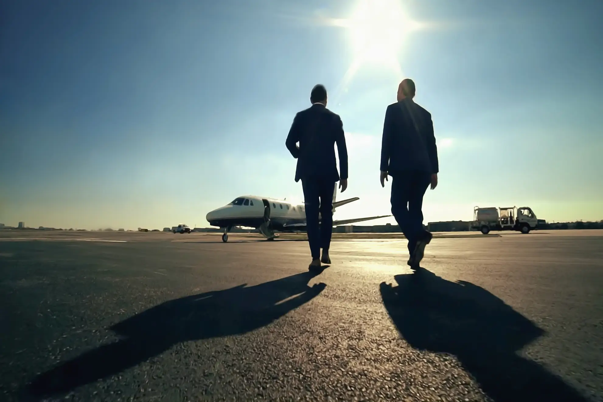 Due professionisti si dirigono verso un jet privato: vantaggi dei voli charter per trasferte sportive efficienti, Flyness.