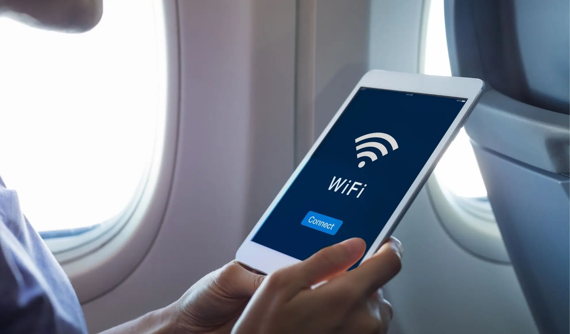 connessione-wifi-in-aereo-tablet Passeggero collega il tablet al Wi-Fi in cabina durante un volo privato Flyness