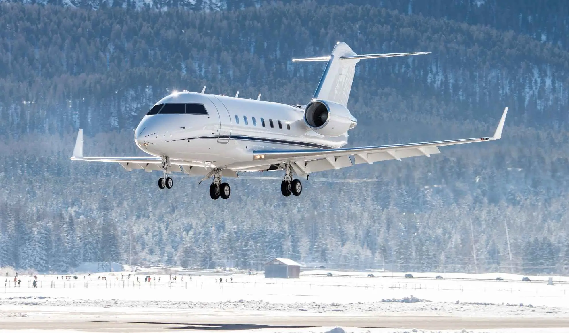 Jet privato in atterraggio su pista innevata in montagna per la settimana bianca 2025-26, Flyness air charter broker.