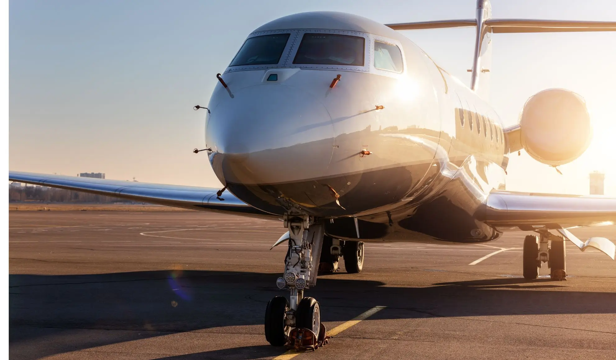 jet-privato-innovazione-tecnologica-avanzata-flyness Jet privato moderno parcheggiato su pista al tramonto, simbolo di innovazione tecnologica nel settore dell’aviazione. Flyness, air charter broker.