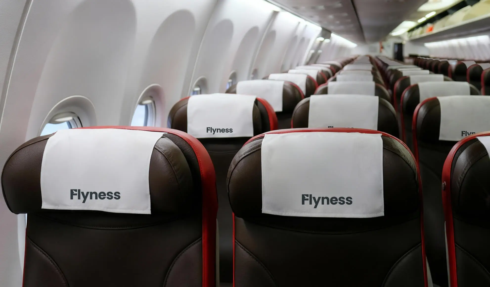 Interno di volo charter Flyness per eventi aziendali, con allestimento personalizzato e poggiatesta brandizzati con logo aziendale.