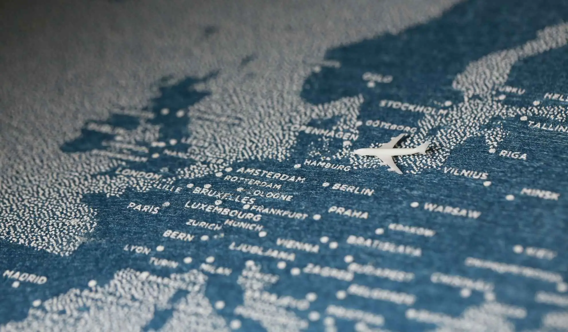 esempio-viaggi-di-lavoro-aereo-multi-citta-europa Aereo sopra una mappa dell’Europa con più città, a indicare un itinerario di viaggio di lavoro multi-tappa