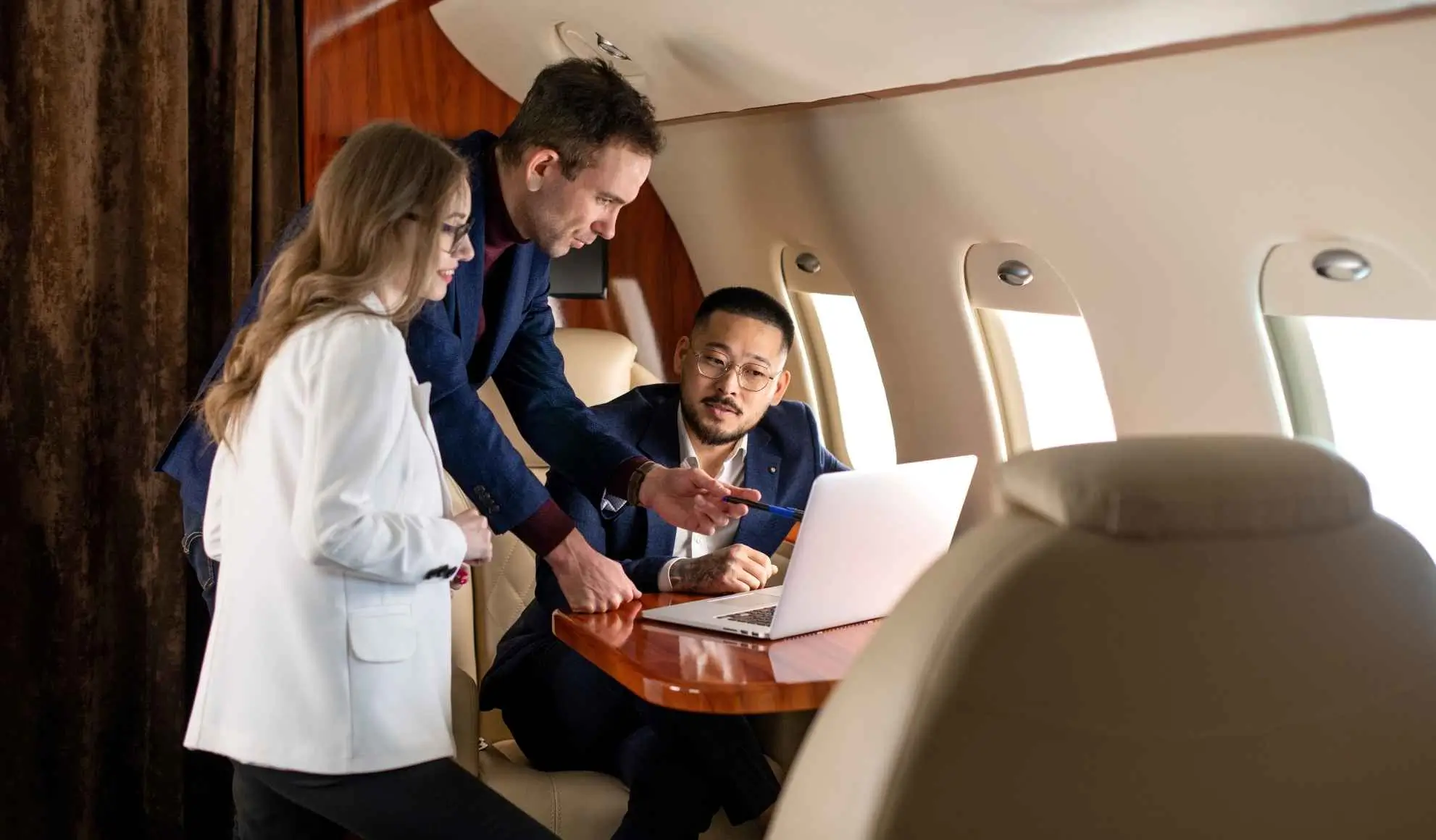 gestione-tempo-viaggi-di-lavoro-lavoro-a-bordo Team che lavora al computer durante un volo, esempio di gestione del tempo nei viaggi di lavoro