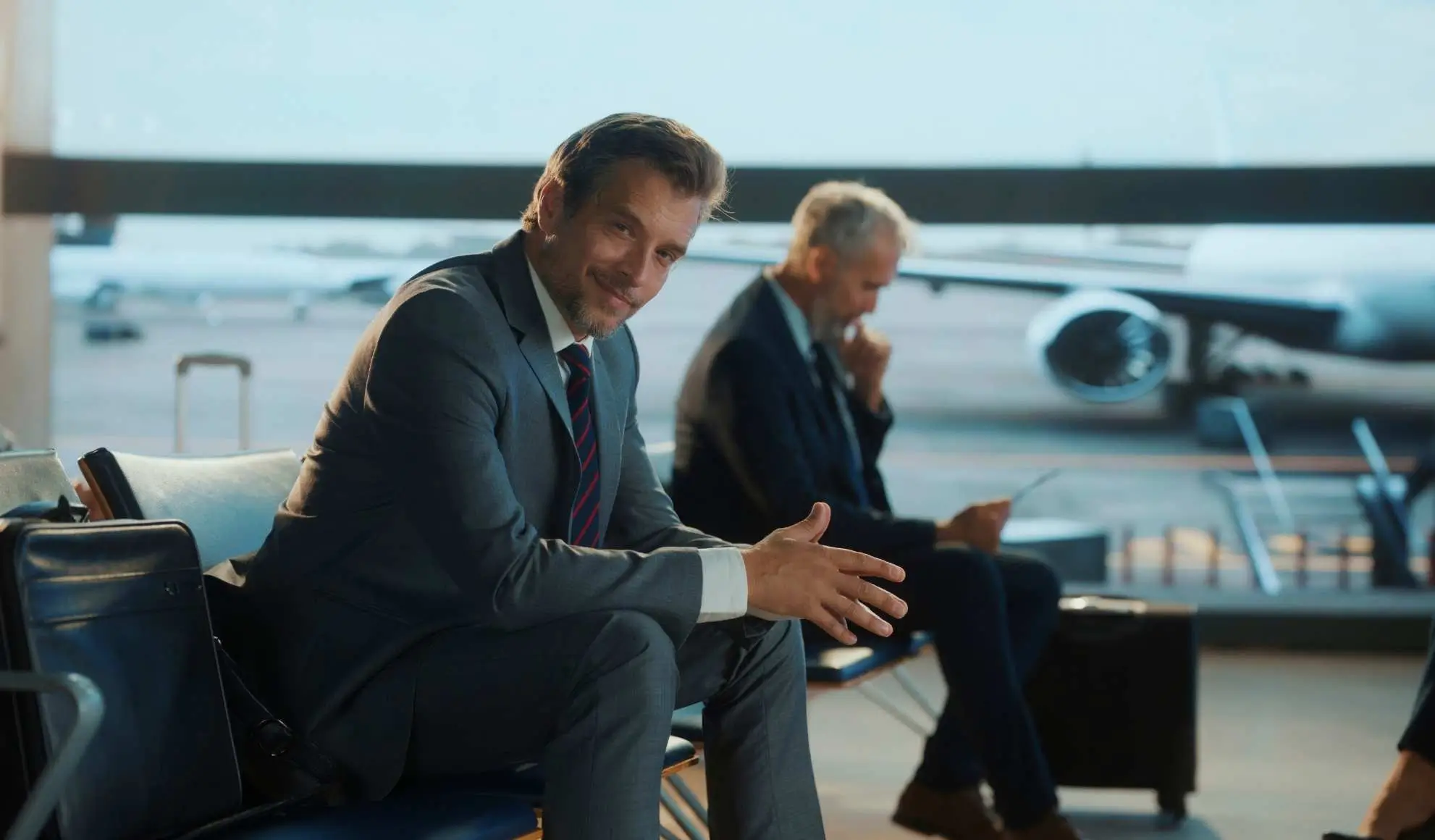 Viaggiatori business in aeroporto mentre valutano la scelta tra voli low cost e charter per eventi aziendali