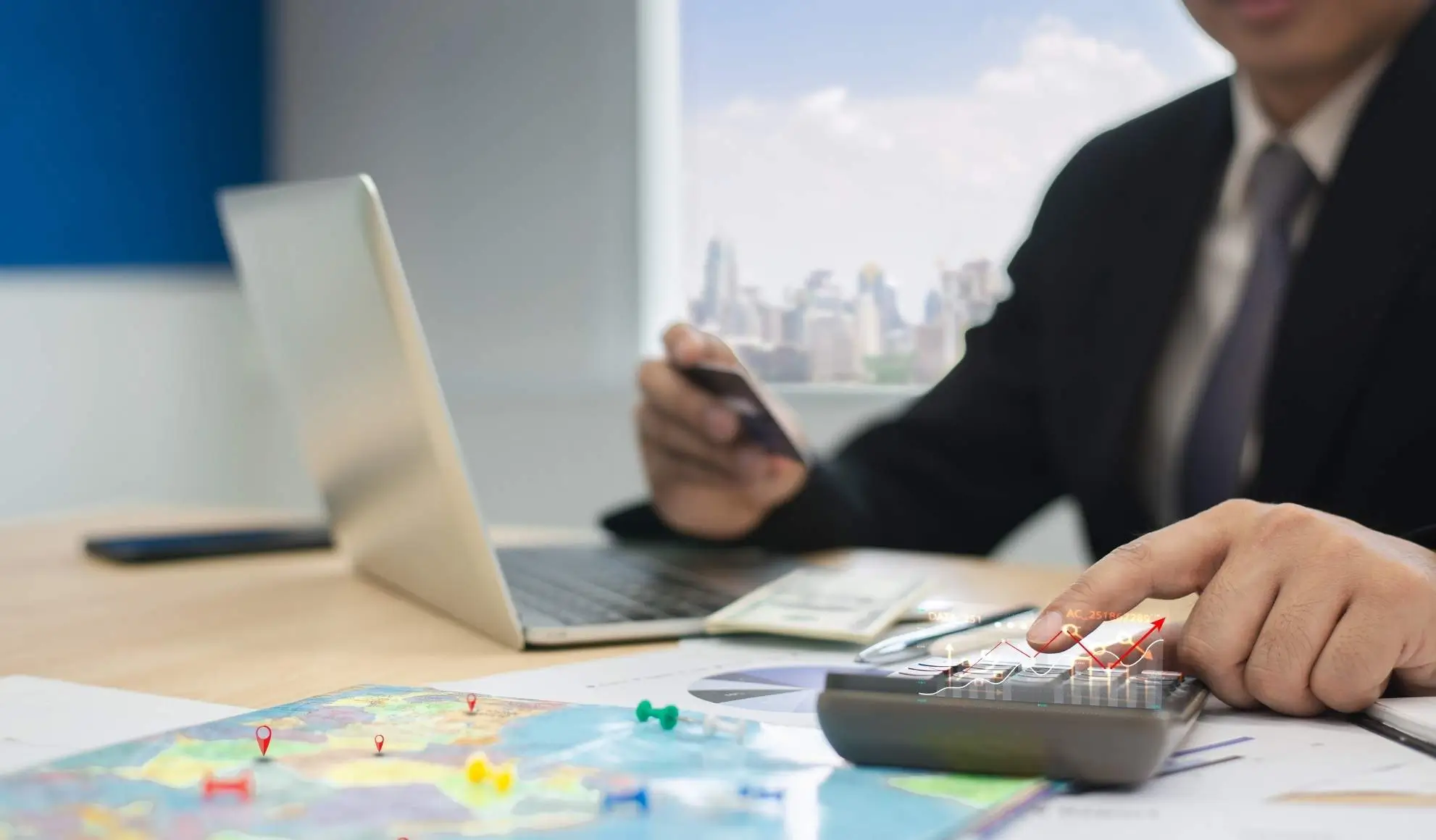 ottimizzazione-costi-voli-business-pianificazione Professionista che analizza costi e pianificazione di un viaggio business con mappa, documenti e calcolatrice sul tavolo.