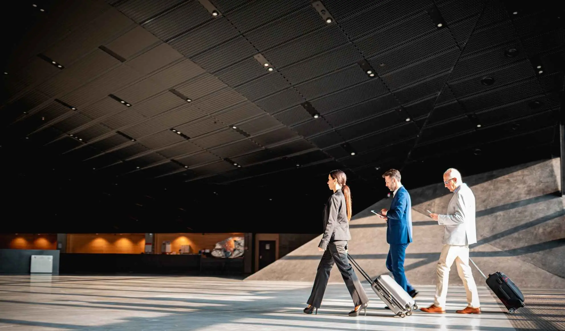 Professionisti in transito in un terminal aeroportuale con bagagli, durante l’organizzazione di una trasferta sportiva