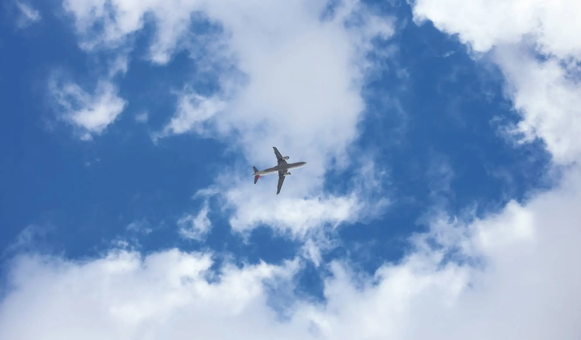 Aereo in volo tra le nuvole, simbolo della crisi dei voli e dell’incertezza nel sistema del trasporto aereo nel 2026