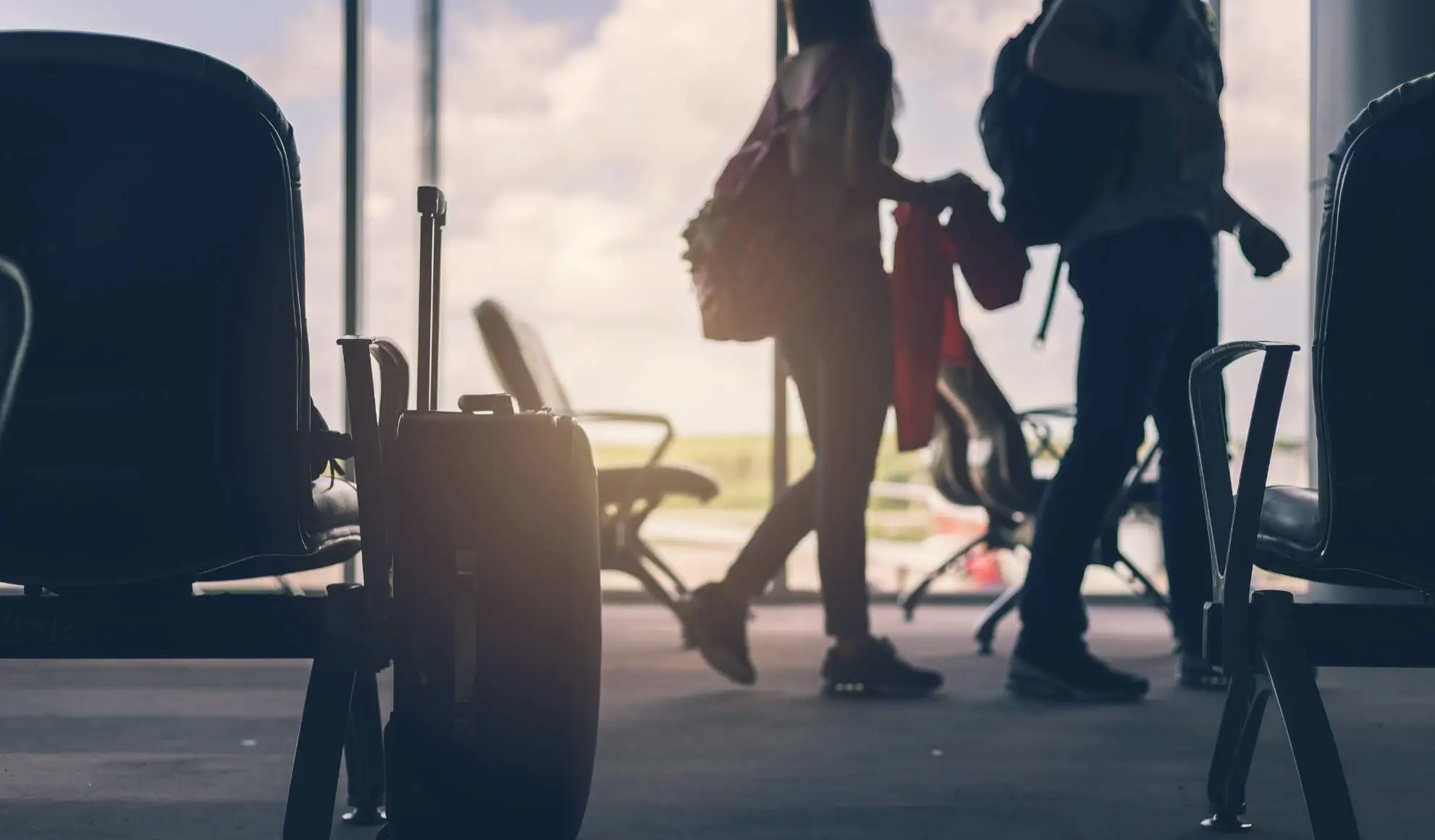 Viaggiatori in movimento in un aeroporto, simbolo di una gestione del viaggio integrata nell’organizzazione sportiva