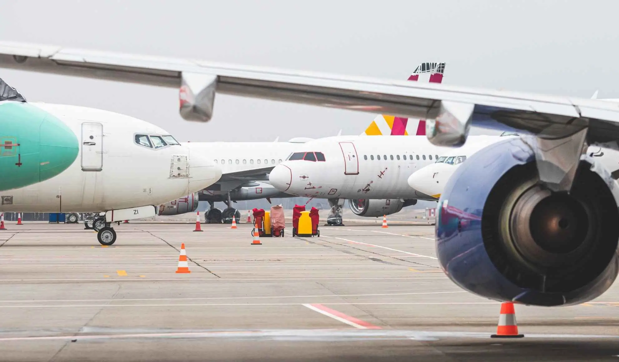 Aeromobili in sosta su piazzale aeroportuale congestionato, simbolo della pressione sul sistema dei voli di linea