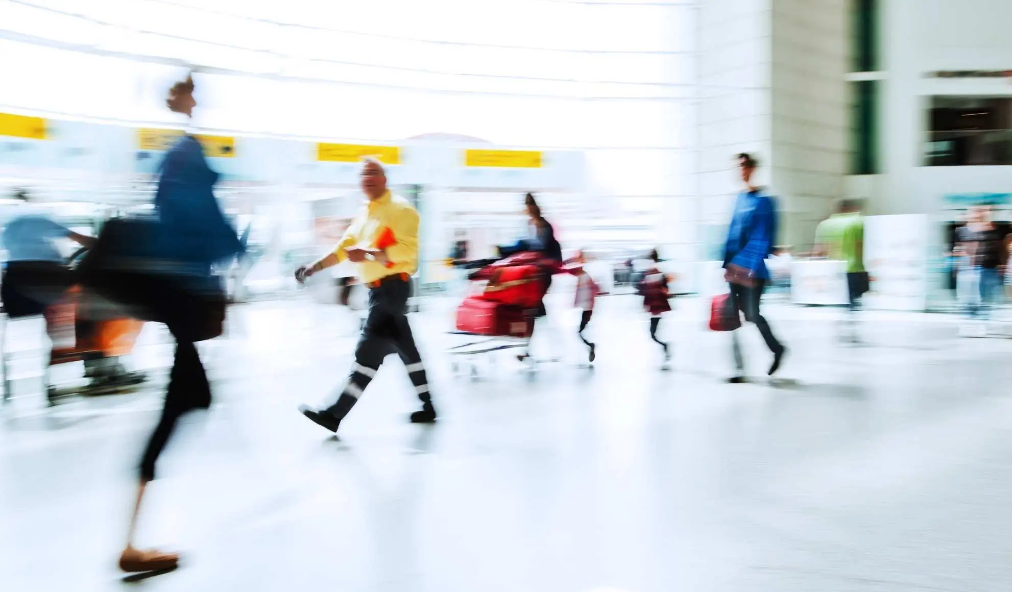 Persone in movimento in un terminal aeroportuale affollato, simbolo della complessità delle trasferte sportive moderne