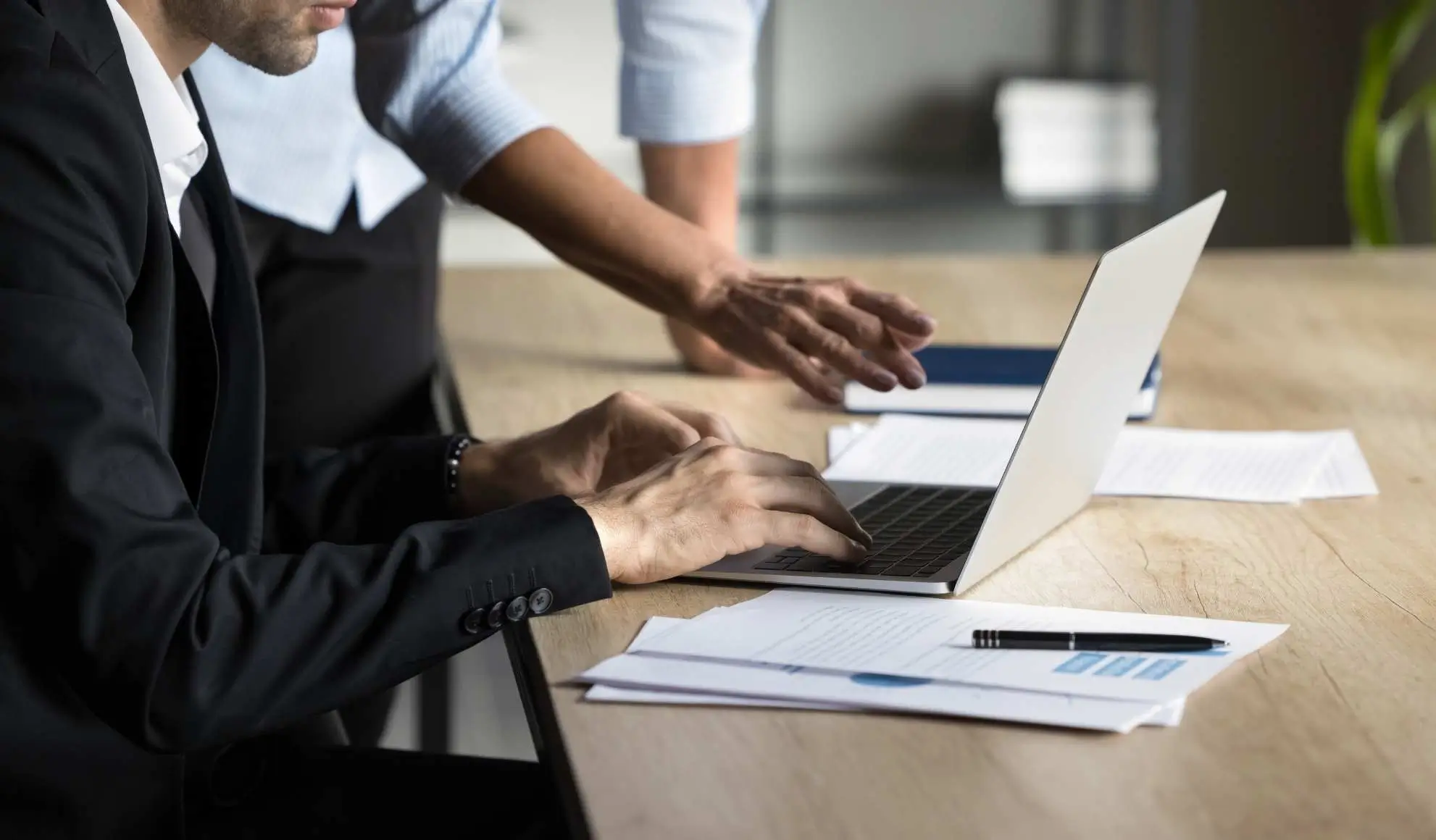 gestione-operativa-sicurezza-privacy-trasferte professionisti che gestiscono documenti e dati su laptop durante la pianificazione della sicurezza e della privacy nelle trasferte sportive
