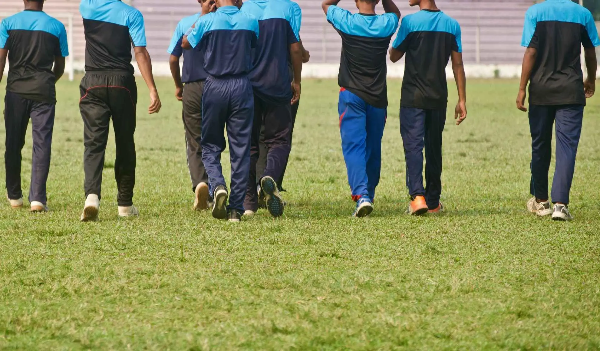 trasferimento-squadra-calcio-gruppo-movimento Squadra di calcio che cammina insieme durante fase iniziale di preparazione e costruzione del gruppo