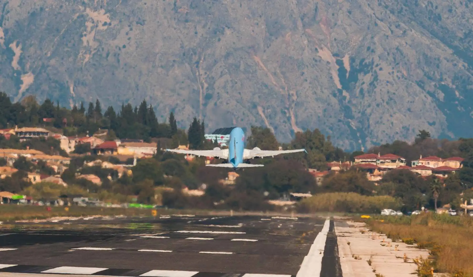 Decollo aereo da pista con montagne sullo sfondo, esempio di aeroporto difficile. Flyness, air charter broker