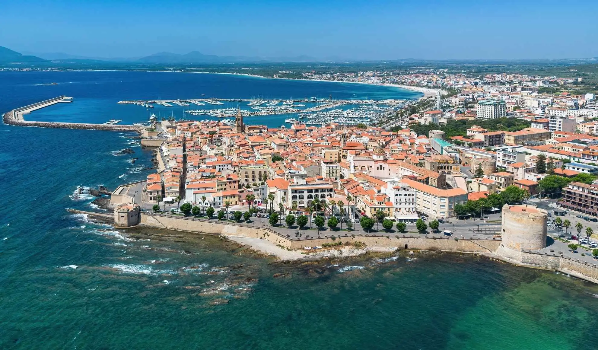 mediterraneo-destinazioni-incentive-citta-costiera Vista aerea di una città costiera del Mediterraneo con porto e marina, simbolo delle destinazioni incentive più richieste per eventi MICE.