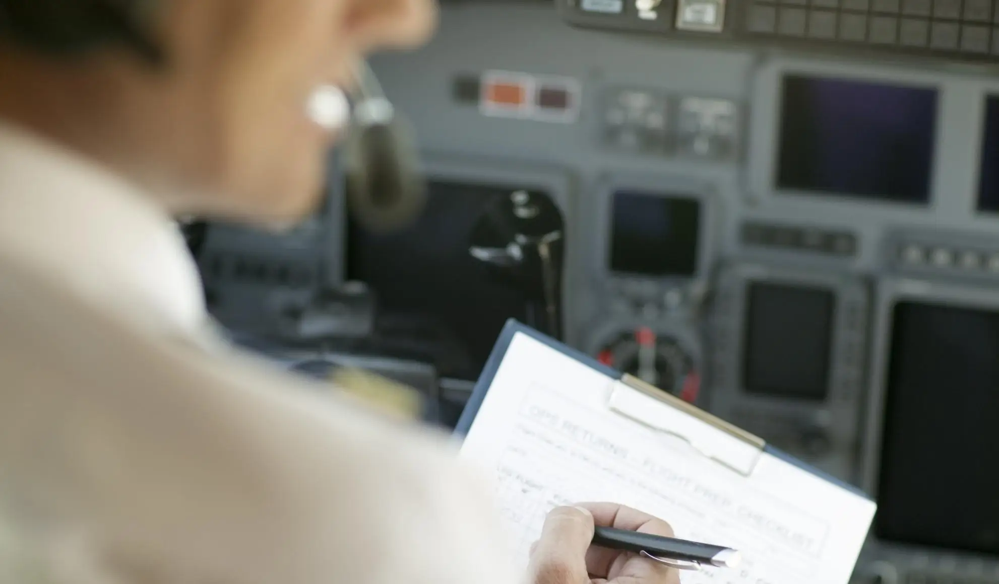 preparazione-volo-checklist-pilota-prima-decollo Pilota controlla la checklist durante la preparazione del volo prima del decollo