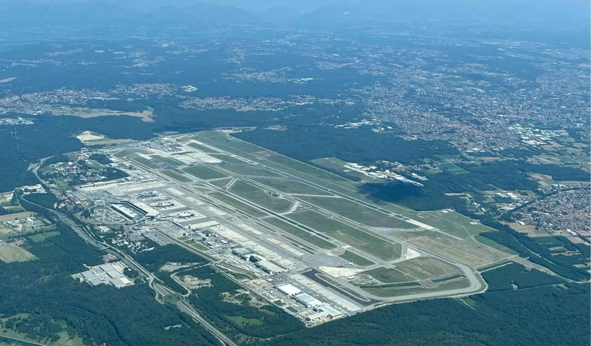 Vista aerea di un aeroporto con piste, raccordi e terminale, utile a mostrare la complessità operativa dello scalo