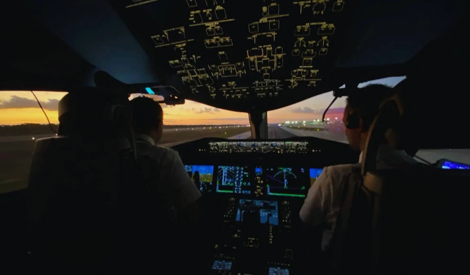 Piloti in cabina durante le operazioni di un volo intercontinentale al tramonto