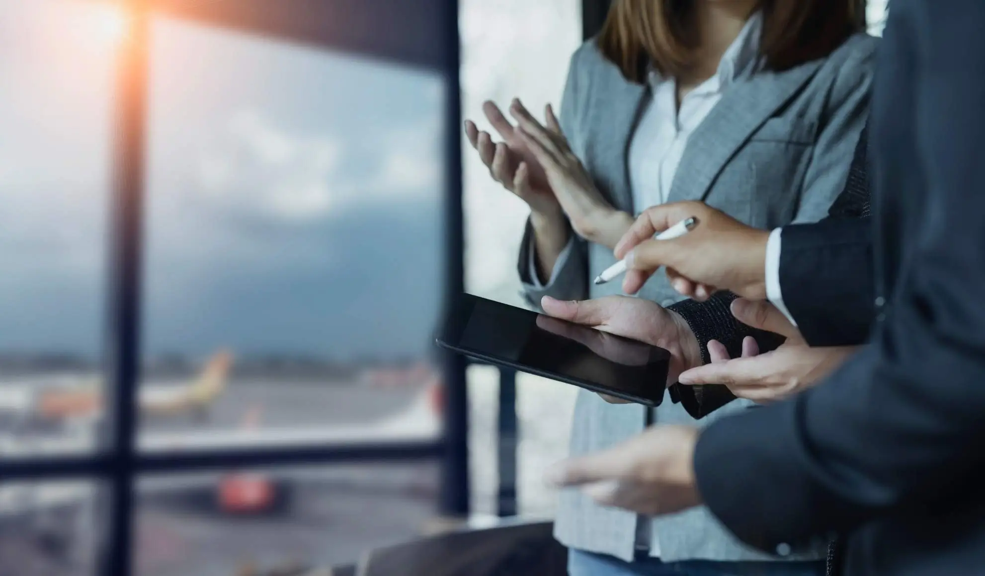 Consulenti aviation analizzano una proposta su tablet in aeroporto, esempio di consulenza Flyness per scegliere il volo charter più adatto