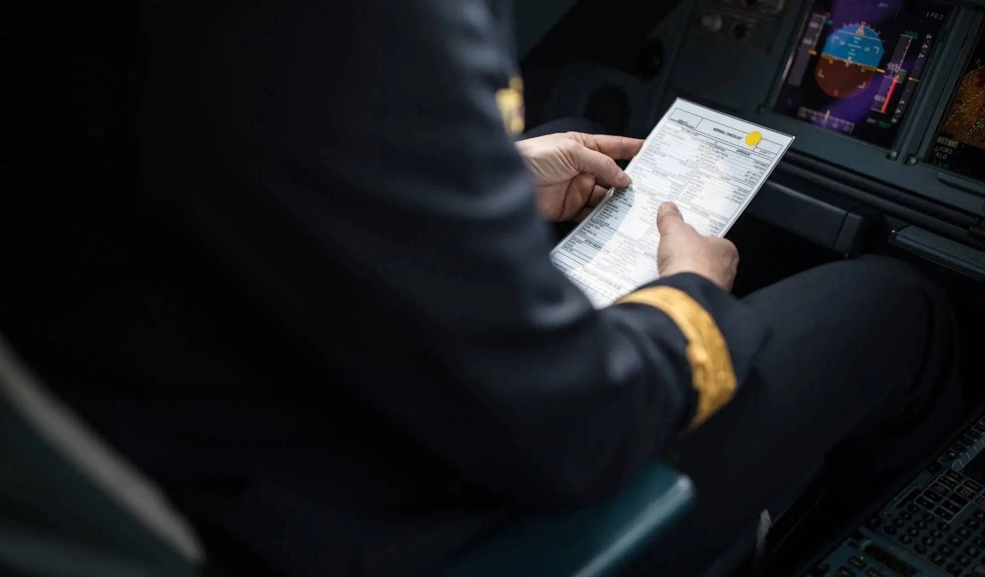 Pilota consulta il piano di volo nella cabina di pilotaggio