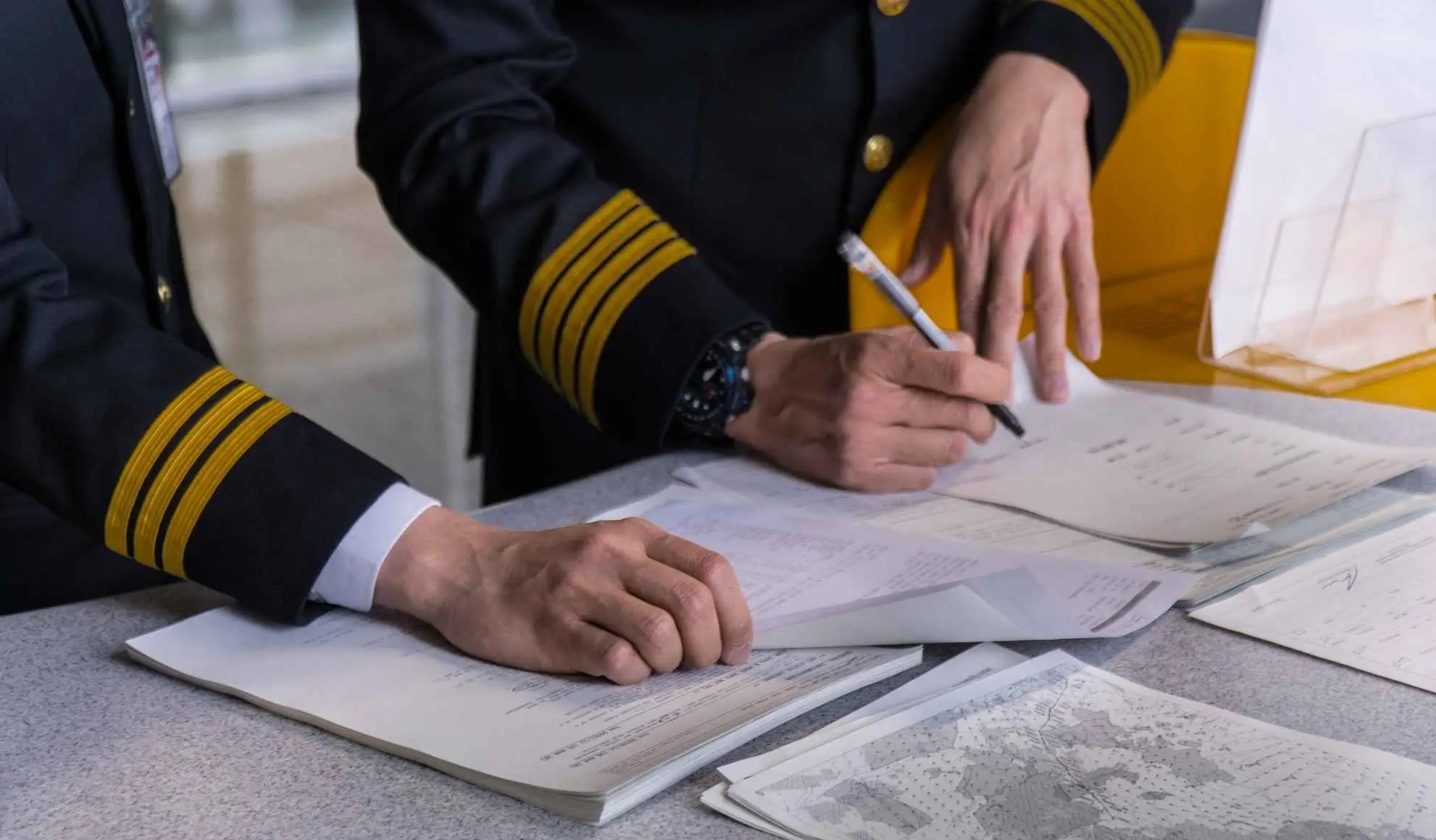 Piloti analizzano documenti e piano di volo durante la preparazione di un volo intercontinentale