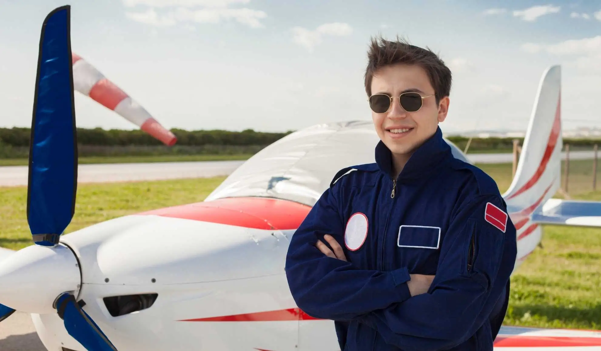 Giovane pilota accanto a un aeromobile da addestramento dopo il primo volo da solo