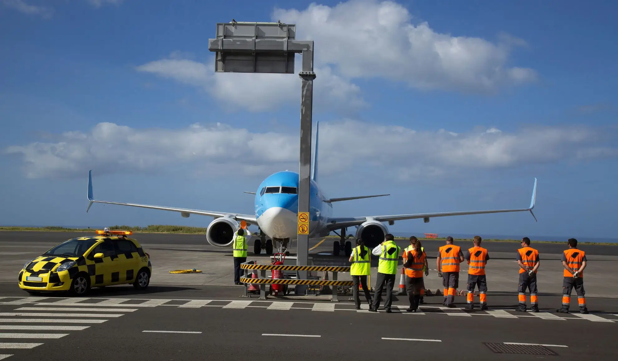 ruoli-coordinamento-handling-aeroportuale-volo-charter Professionisti aeroportuali coordinano le operazioni di handling davanti a un aeromobile charter.