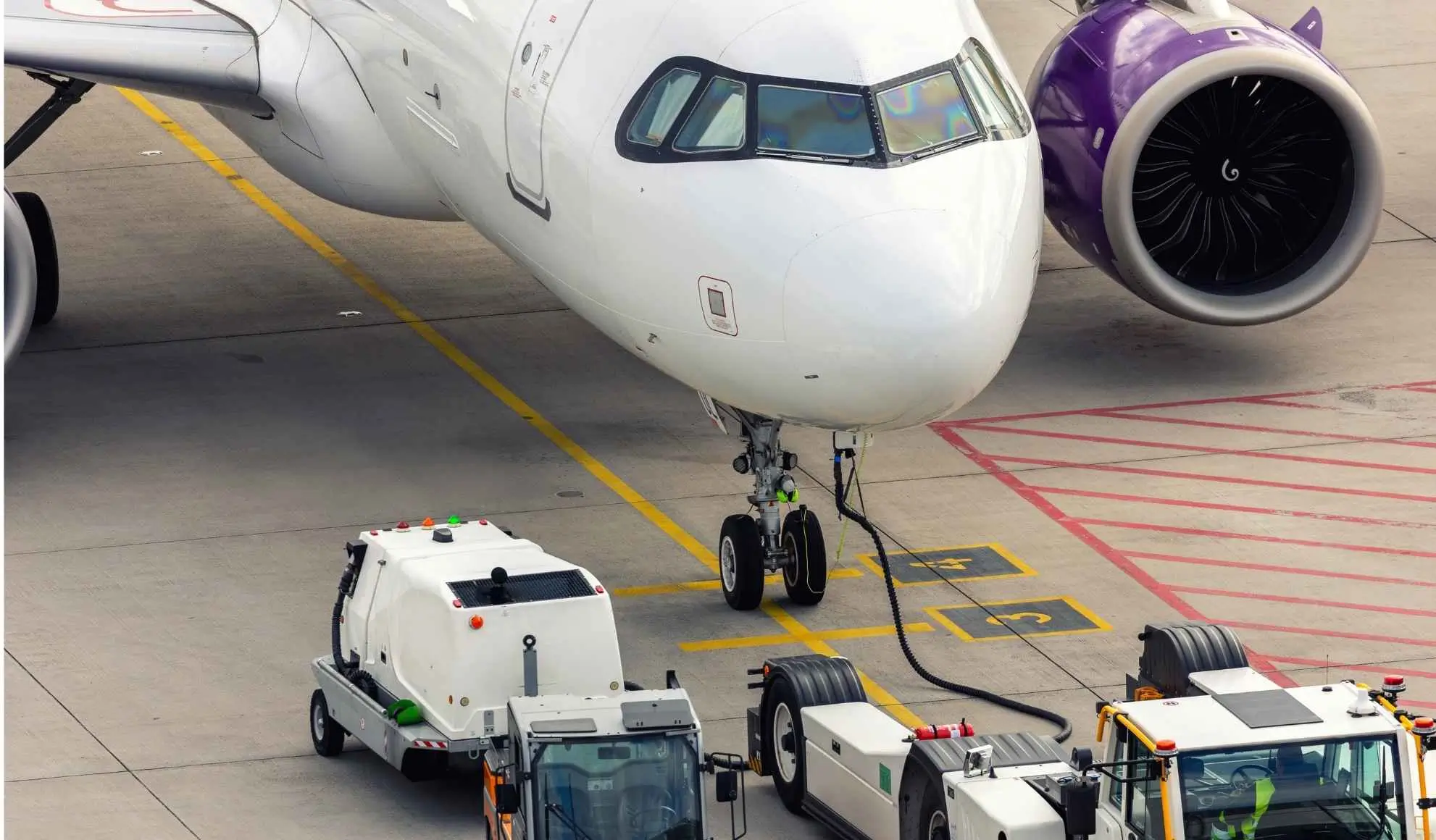 Aereo charter sul piazzale aeroportuale con mezzi di handling a terra, simbolo di operatività e coordinamento nei voli charter Flyness
