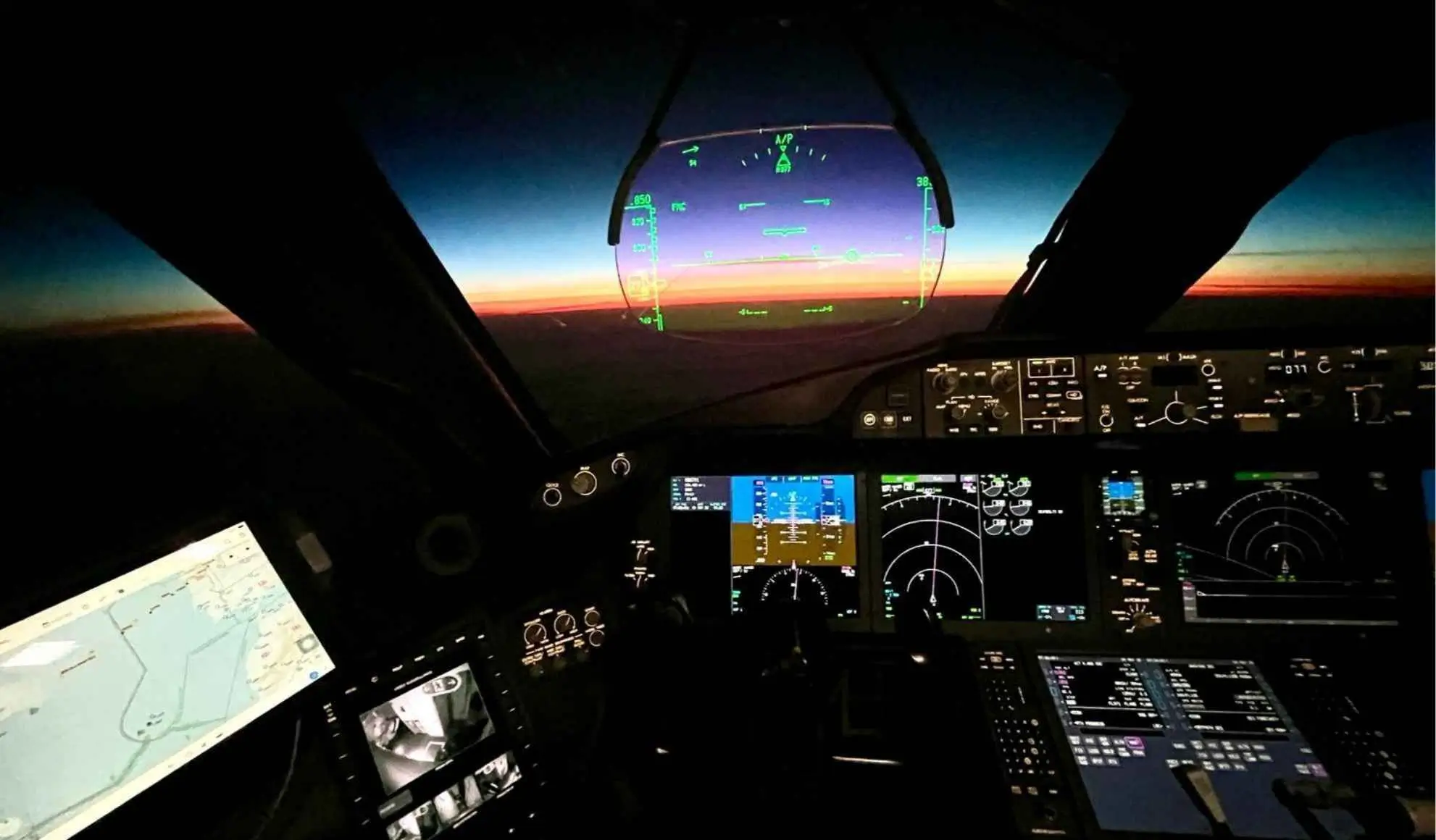 Cabina di pilotaggio durante un volo lungo raggio, con strumenti di bordo e orizzonte all’alba